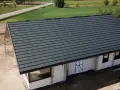 Nowy dom w budowie z ciemnoszarym dachem, widok z góry.