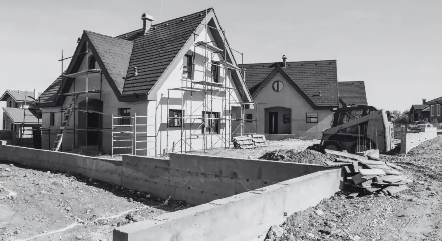 Domy w budowie, rusztowania, koparka i materiały budowlane. Mam pozwolenie na budowę, co dalej? Czas na realizację marzeń o własnym domu.