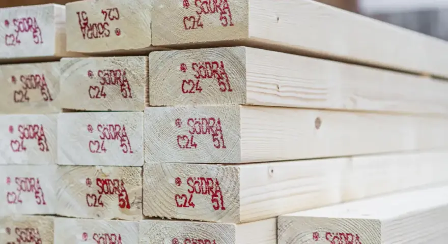 Stos belek drewna konstrukcyjnego C24 z czerwonymi oznaczeniami.